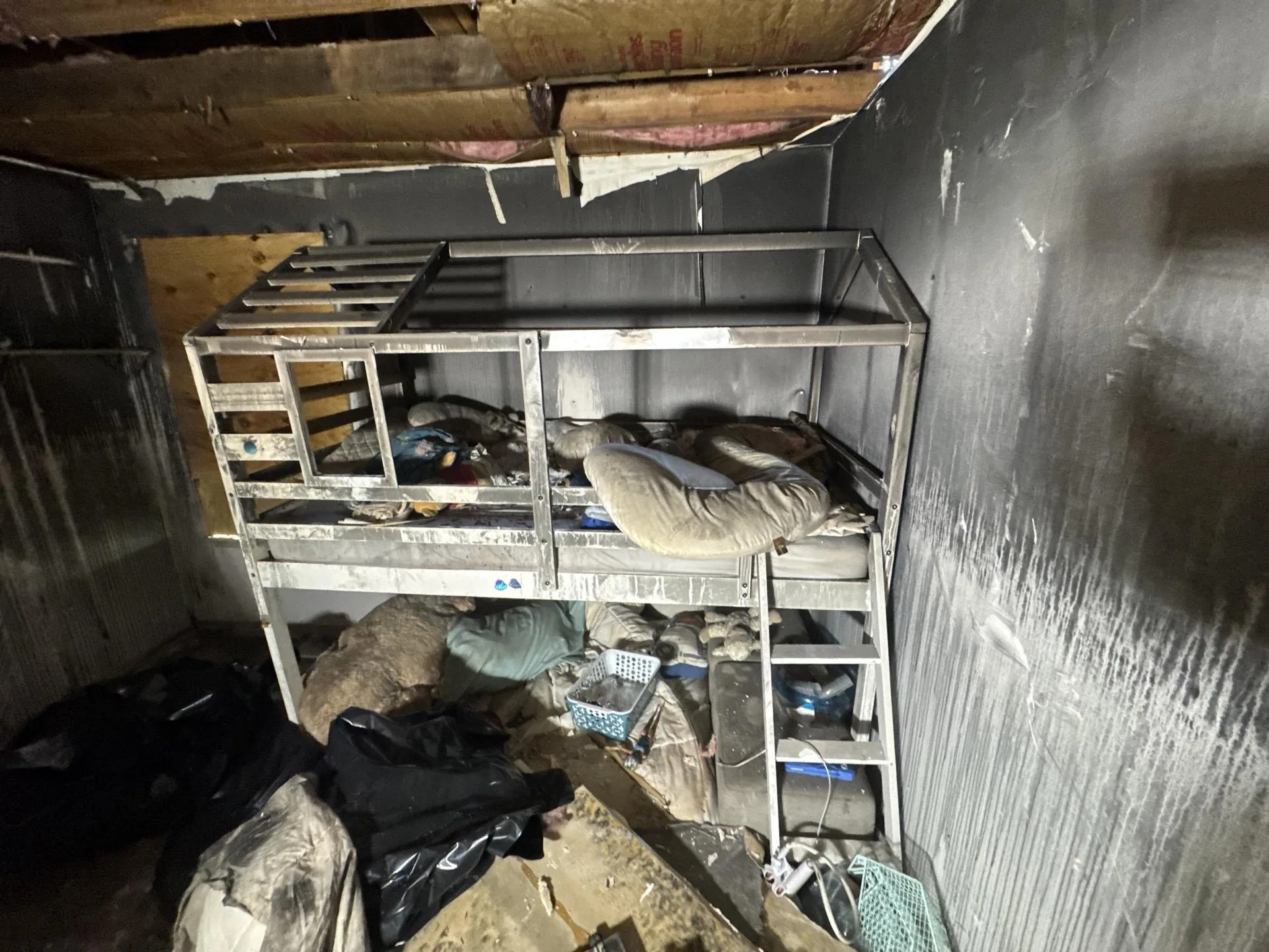 Fire-damaged room with charred walls and an open burned ceiling